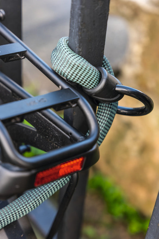 Slow green ABUS Infinity loop wrapped around railing to secure bicycle