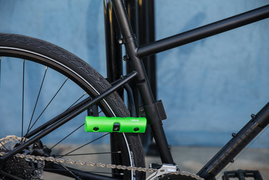 black bike secured to bike rack with ABUS Ultra 410 u-lock through rear wheel.