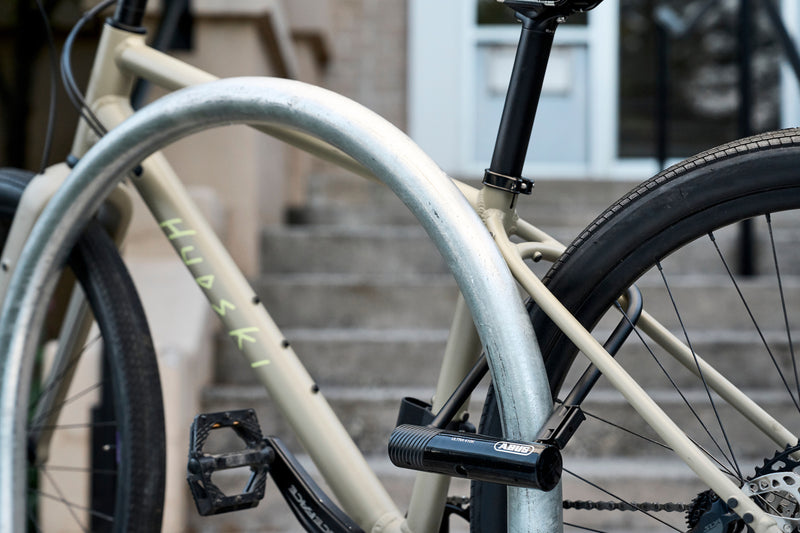 Load image into Gallery viewer, Black ABUS Ultra 410K securing beige bicycle to bike rack #color_black
