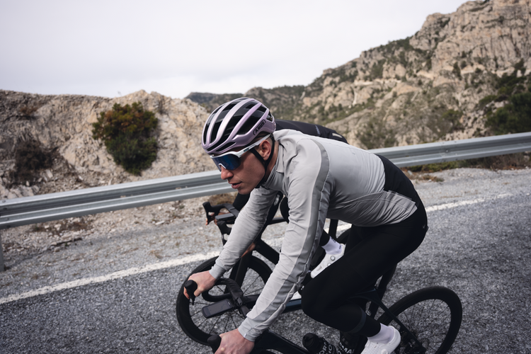 Cyclist on a mountain road with rocky landscape