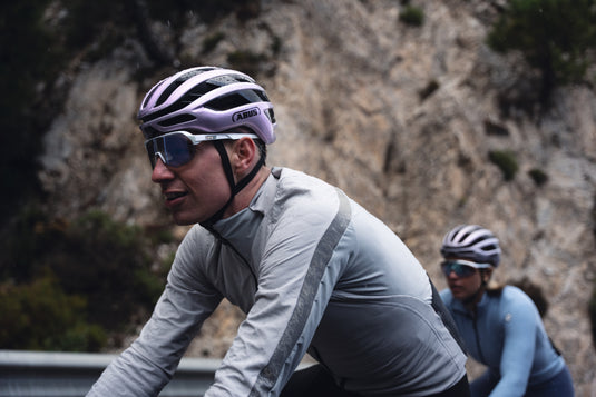 riider climbing road in mountains wearing ArBreaker 2.0 with another rider in background