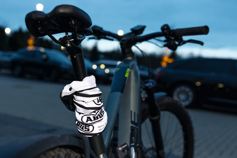 Load image into Gallery viewer, Bicycle with a glove on the handlebar against a blurred background of cars and lights #color_reflective
