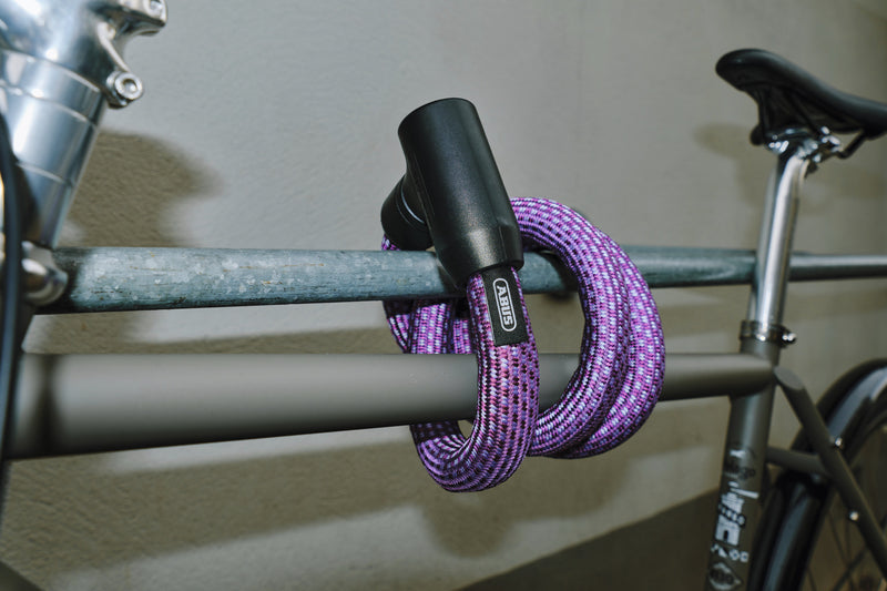 Load image into Gallery viewer, Purple bike lock on a bicycle frame against a neutral background #color_midnight purple
