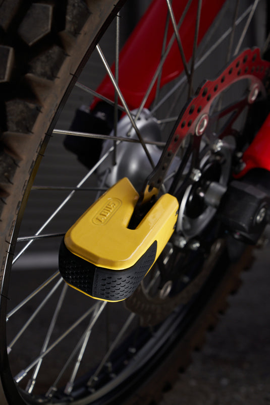 Yellow lock attached to a motorcycle wheel