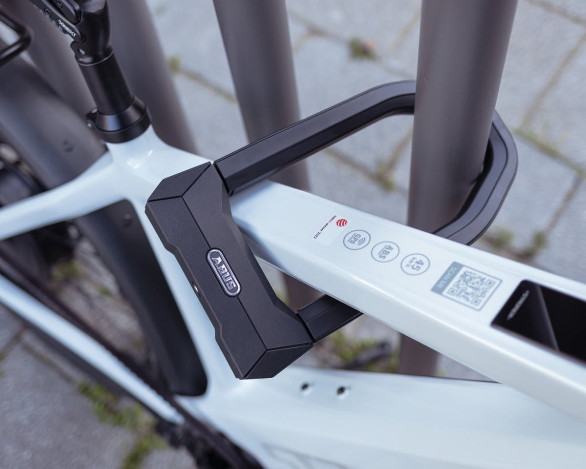 ABUS GRANIT Super Extreme 2500 u-lock securing white bike to railing #size_230mm