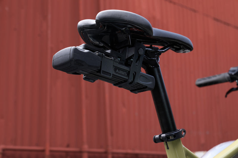 Load image into Gallery viewer, Bicycle seat with Bordo 6000K Saddlefix mounted against a red metal wall

