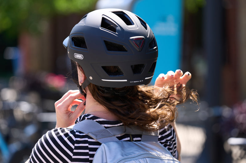 Load image into Gallery viewer, Cyclist adjusting fit of black Hyban 2.0 MIPS helmet
