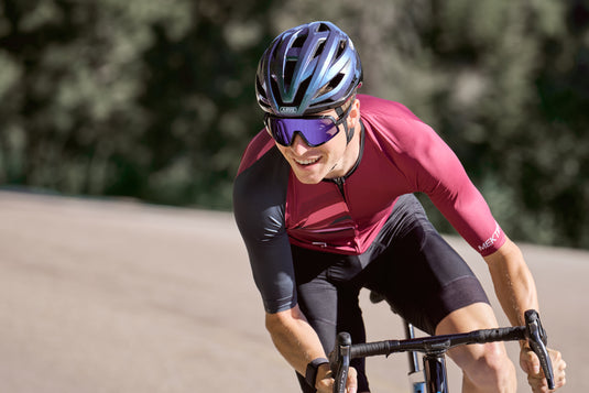 Cyclist cornering on road wearing purple ABUS StormChaser helmet
