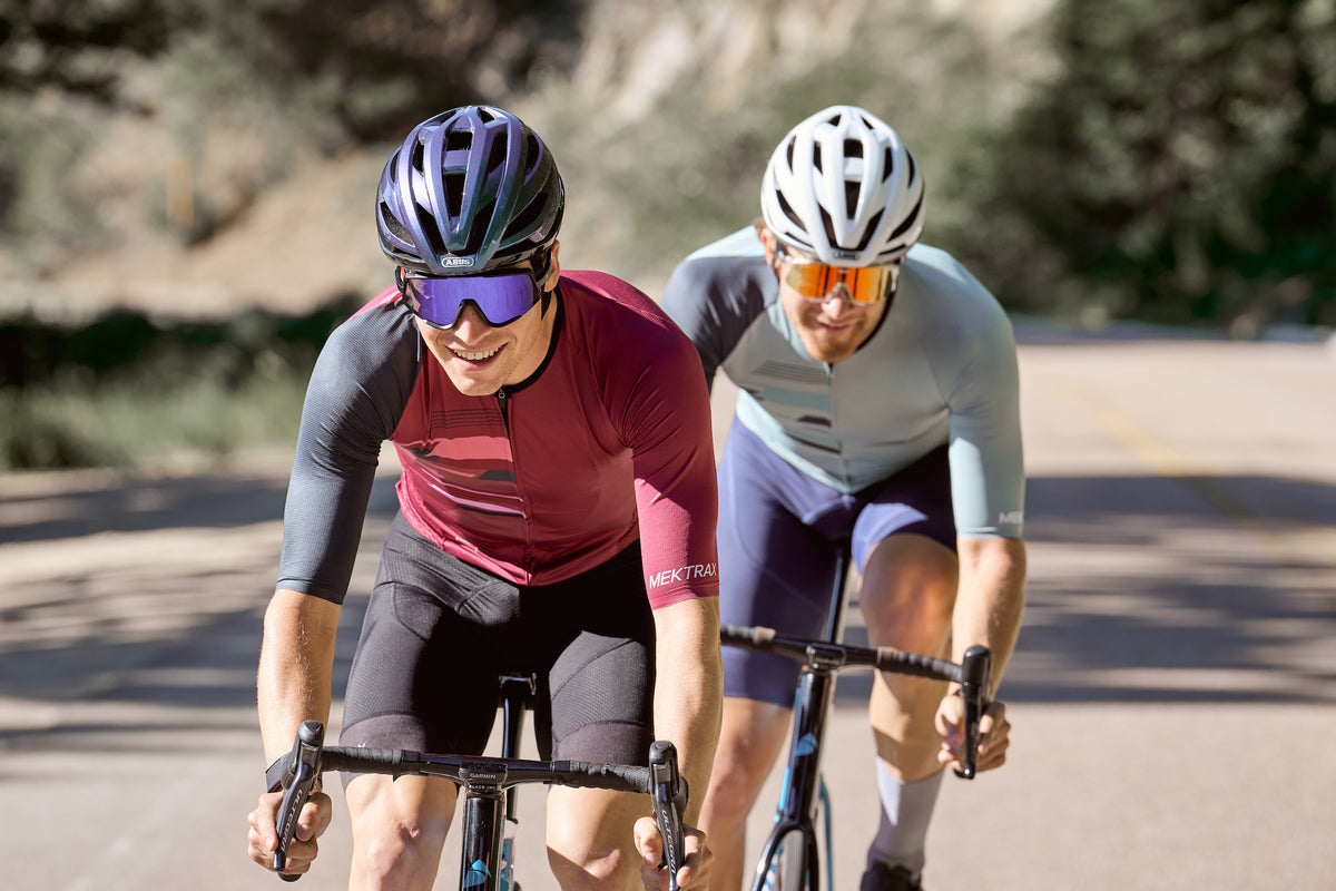 Two cyclists riding sngle file wearing ABUS StormChaser helmets