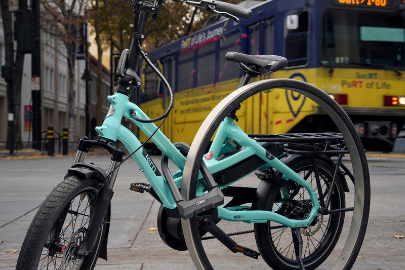 Load image into Gallery viewer, ABUS GRANIT XPlus 2500 sercing turquoise e-bike to rack with train in background #size_230mm

