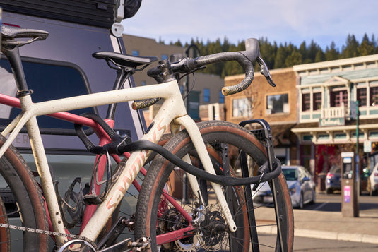 Infinity Loop 1806 securing two bicycles to hitch rack in downtown setting