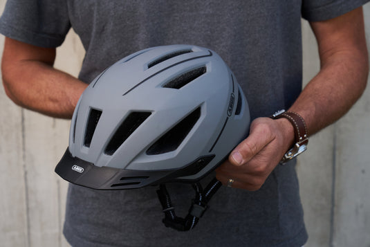 Concrete Grey Pedelec 2.0 MIPS helmet being held in hands