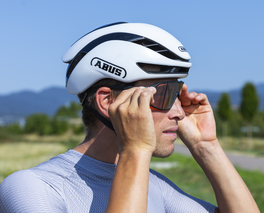 cyclist adjusting glasses while wearing white ABUS GameChanger 2.0 helmet 